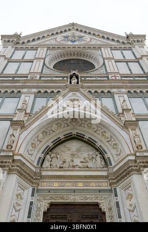 Zentrales Portal der Basilika Santa Croce in Florenz mit gotischem Marmorbogen und Lünettenrelief des Triumphes des Kreuzes von Giovanni Dupre, reich oder Stockfoto
