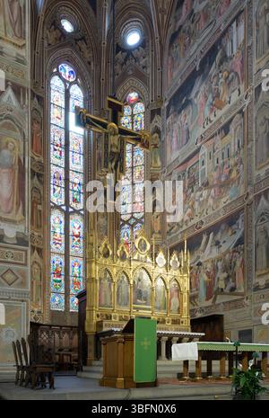 Gotische Apsis der Basilika Santa Croce in Florenz, mit dem Freskenzyklus von Agnolo Gaddi, Buntglasfenstern, Hochaltar und Kruzifix. Stockfoto