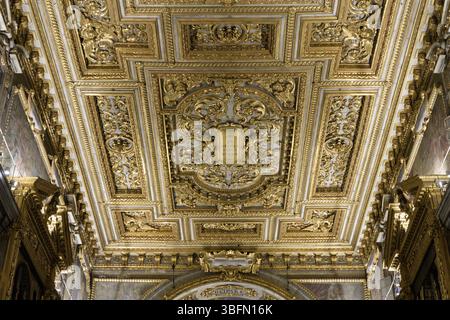 Vergoldete Kassettendecke von Santissima Annunziata in Florenz, verziert mit barocken Ornamenten, klassischen Motiven und einer lateinischen Kartusche. Stockfoto