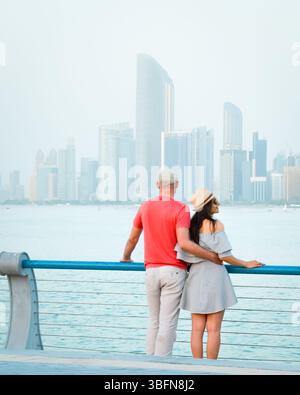 Kaukasische Touristen romantische Paare stehen zusammen und genießen das Panorama der Skyline auf dem malerischen Aussichtspunkt in Abu dhabi. Besuchen Sie die Reise Sightseeing VAE Concept Stockfoto