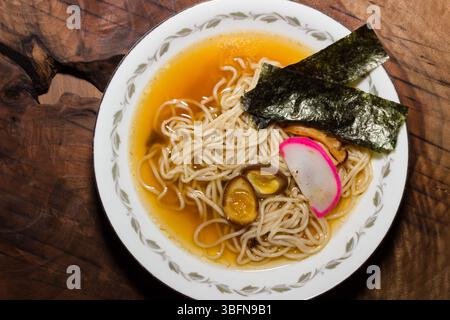 Es wird eine Schüssel Ramen serviert, mit Nudeln, Brühe, Algen, Eiern, und Kamaboko, das eine wohltuende und geschmackvolle Mahlzeit anbietet. Stockfoto