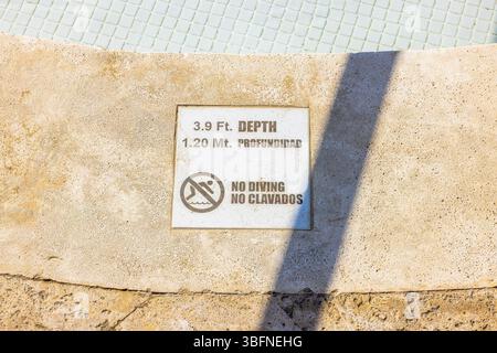 Das Tiefenwarnschild am Beckenrand zeigt 3,9 ft und 1,20 m, ohne Tauchsymbol und zweisprachigen Text. Punta Cana. Dominikanische Republik. Stockfoto