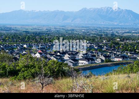 Santaquin, Utah – 2. Juni 2025: Weite Sicht auf ein Wohnviertel mit bergiger Kulisse und offenem Tal unter klarem Himmel. Stockfoto