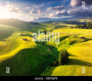 Blick aus der Vogelperspektive auf grüne Almwiesen mit Häusern auf den Hügeln Stockfoto