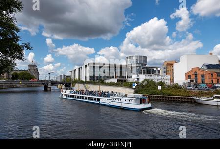 Deutschland, Berlin, 26.05.2025, Bootstour auf der Spree in Berlin. Ein Sightseeing-Boot segelt entlang der Spree in Berlin, vorbei an modernem und Stockfoto