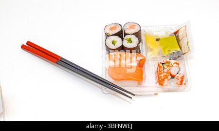 Traditionelles rohes Fisch Sushi und Sashimi in einer Plastikbox zum Mitnehmen mit Essstäbchen Stockfoto