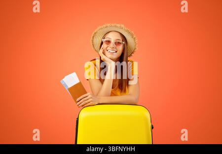 Glückliche junge Frau in Sonnenbrille mit Pass und Tickets Stockfoto