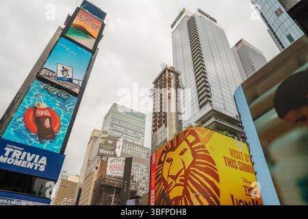 New York City, New York, USA - 07.29.2024: Eine Mischung aus hellen digitalen Anzeigen und Wolkenkratzern beleuchtet den Times Square. Die Schilder von Coca-Cola und Lion King sind auffällig. Stockfoto