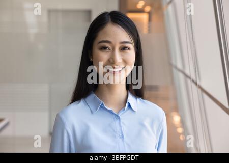 Kopfaufnahme einer jungen asiatischen Geschäftsfrau, die in die Kamera schaut Stockfoto