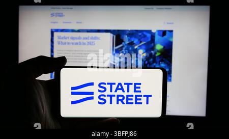 Stuttgart, Deutschland - 23.01.2025: Person, die ein Mobiltelefon mit dem Logo der US-amerikanischen Finanzgesellschaft State Street Corporation auf dem Bildschirm hält Stockfoto