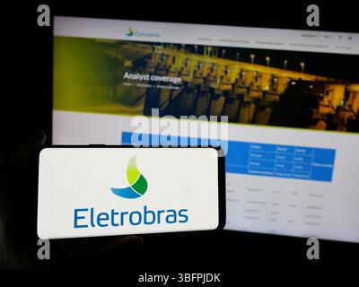 Stuttgart, Deutschland - 23. 01. 2025: Person mit Smartphone mit Logo von Centrais Eletricas Brasileiras S.A. (Electrobras) auf dem Bildschirm Stockfoto