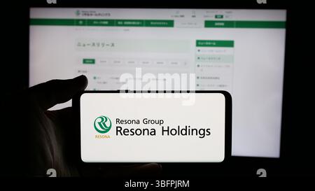 Stuttgart, Deutschland - 23.01.2025: Person, die ein Mobiltelefon mit dem Logo der japanischen Bankgesellschaft Resona Holdings Inc. Auf dem Bildschirm hält Stockfoto