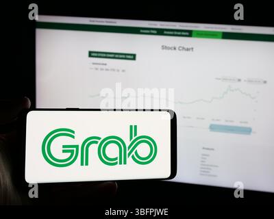Stuttgart, Deutschland - 23.01.2025: Person mit Smartphone mit Logo des singapurischen Technologieunternehmens Grab Holdings Inc. Auf dem Bildschirm Stockfoto