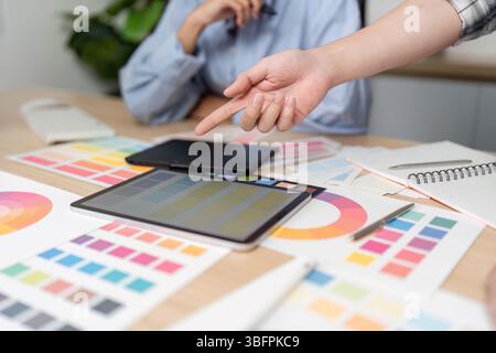 Zusammenarbeit bei UX- und UI-Design. Kreatives Team diskutiert Farbpaletten und Designelemente. Stockfoto