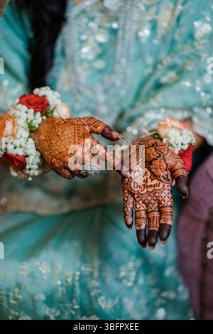Nahaufnahme von Henna an den Händen einer indischen Frau. Indische Mehendi-Feier. Henna-Anwendung und Rituale. Frauenhände mit Henna-Hochzeitsmotiv Stockfoto