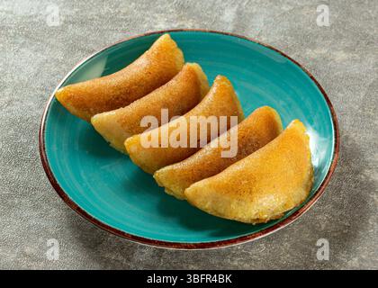 Ramadan Qatayef-Dessert auf einem dekorativen Teller, traditionelles Gebäck aus dem Nahen Osten, das während der Iftar- und Eid-Feierlichkeiten serviert wird Stockfoto