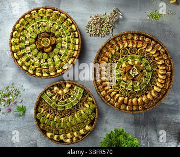 Blick von oben auf ein luxuriöses Sortiment an arabischen Süßigkeiten, perfekt für Gastfreundschaft und Eid, mit Pistazien-Baklava, Pistazien-Brötchen und anderen osmanischen Stockfoto