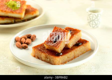 Klassisches Nahost-Namoura-Dessert mit Ghee und Nüssen, serviert auf weißem Hintergrund Stockfoto