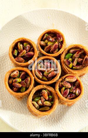 Blick von oben auf Pistazien-Nussbrötchen, traditionelles Dessert aus dem Nahen Osten, serviert mit Sirup Stockfoto