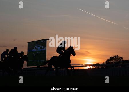 Windsor, Berkshire, Großbritannien. Juni 2025. Jockeys und Rennpferde stehen vor der Skyline, wenn die Sonne auf der Royal Windsor Racecourse in Windsor, Berkshire, während des letzten Rennens des Abends bei Monday Night Racing untergeht. Das Wetter wird sich diese Woche ändern, mit der Regenvorhersage für die nächsten Tage. Quelle: Maureen McLean/Alamy Live News Stockfoto