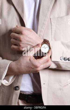 Junger Mann im leichten Anzug mit Armbanduhr, Großaufnahme Stockfoto