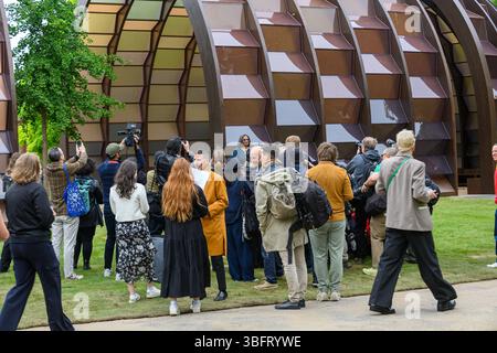 London, Großbritannien. Juni 2025. Der Serpentine Pavilion 2025, Eine Kapsel in Time, entworfen von der bangladeschischen Architektin und Pädagogin Marina Tabassum und ihrer Firma Marina Tabassum Architects (MTA), wird am 6. Juni 2025 eröffnet. Goldman Sachs unterstützt das jährliche Projekt zum 11. Jahr in Folge. Aus Holz gefertigt und um einen halbReifen Ginkgo-Baum gebaut (eine klimaresistente Baumart, die aus dem frühen Jura stammt) und eine Hälfte des Pavillons kann sich bewegen, um eine neue Konfiguration zu schaffen. Quelle: Mary-Lu Bakker/Alamy Live News Stockfoto