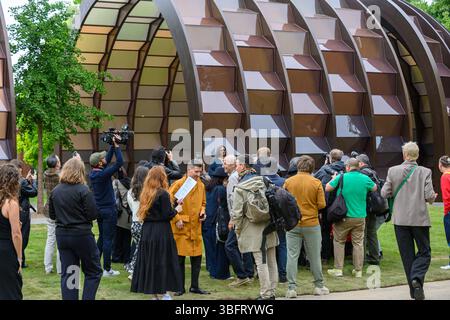 London, Großbritannien. Juni 2025. Der Serpentine Pavilion 2025, Eine Kapsel in Time, entworfen von der bangladeschischen Architektin und Pädagogin Marina Tabassum und ihrer Firma Marina Tabassum Architects (MTA), wird am 6. Juni 2025 eröffnet. Goldman Sachs unterstützt das jährliche Projekt zum 11. Jahr in Folge. Aus Holz gefertigt und um einen halbReifen Ginkgo-Baum gebaut (eine klimaresistente Baumart, die aus dem frühen Jura stammt) und eine Hälfte des Pavillons kann sich bewegen, um eine neue Konfiguration zu schaffen. Quelle: Mary-Lu Bakker/Alamy Live News Stockfoto