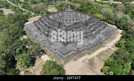 Bewundern Sie den majestätischen Borobudur, den größten buddhistischen Tempel der Welt, der sich aus der üppigen javanischen Landschaft erhebt. Seine komplizierten Terrassen und Stupas erzählen Stockfoto