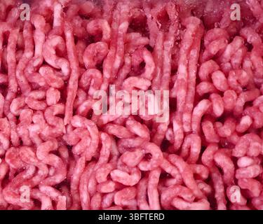 Dieses frisch zubereitete Hackfleisch zeigt eine leuchtende rosa Farbe, die seine Qualität anzeigt. Er ist ordentlich angeordnet, hebt seine Textur hervor und wird gelesen Stockfoto