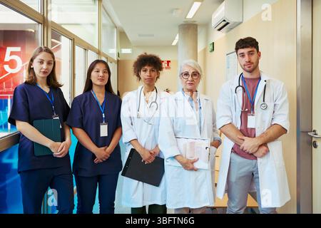 Medizinisches Team posiert im Krankenhauskorridor, Gesundheitsfachkräfte vereint Stockfoto