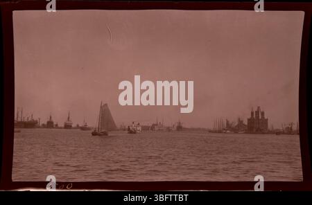 1913 ist der Hafen von Amsterdam mit Dampfschiffen, Segelbooten und Binnenschiffen im Hafen geschäftig. Dieses Foto wurde während der Europa-Tour der Arrases aufgenommen und zeigt die geschäftige Uferpromenade von Amsterdam. Edmund F. Arras, ein Geschäftsmann aus Columbus, dokumentierte europäische Städte durch seine Reisen und bewahrte wertvolle historische Bilder vor dem Ausbruch des Ersten Weltkriegs Stockfoto