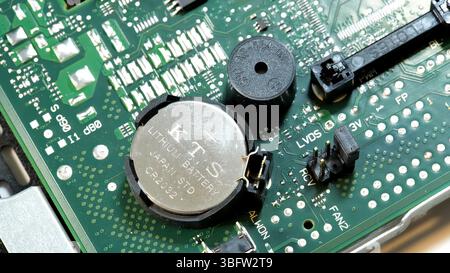 Nahaufnahme einer neuen ersetzten Lithium-Ionen-BIOS-CMOS-Taste CR2032 auf einer Computerplatine, detaillierte Ansicht der Uhrenbatterie auf der Leiterplatte, Stockfoto
