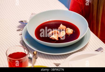 Traditionelle polnische rote Borschtsch-Rote-Bete-Suppe mit Knödeln serviert, festlicher Tisch, Barszcz Czerwony z uszkami Nahaufnahme des klassischen polnischen weihnachtsabends Stockfoto