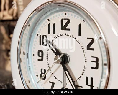 Analoge Vintage-Uhr aus Nahaufnahme mit kräftigen schwarzen Zahlen und weißem Rahmen, Retro-Uhr aus dem osteuropäischen Wohnblock, Wohnzimmereinrichtung, klein Stockfoto