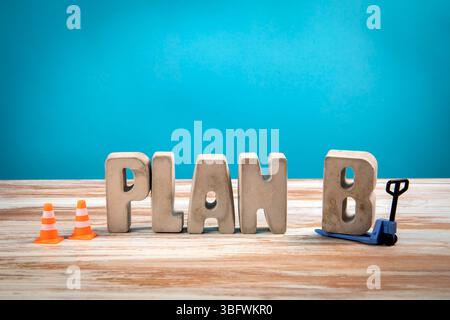 Plan B. Betonbuchstaben auf weißem hölzernem und blauem Hintergrund. Stockfoto