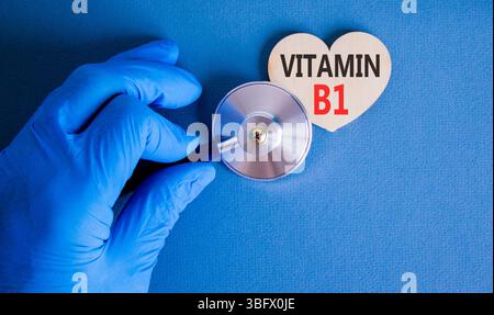 Vitamin B1-Symbol. Concept Words Vitamin B1 auf wunderschönem hölzernen Herzen. Arzthand in blauem Medizinhandschuh. Stethoskop. Wunderschöner blauer Hintergrund. Ich Stockfoto