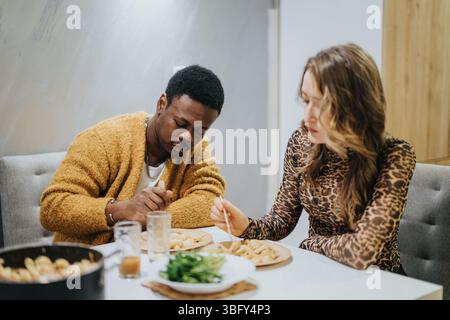 Ein Paar genießt ein gemütliches Essen an einem gemütlichen Tisch Stockfoto