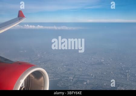 Erde- und Planflügelansicht von einem Strahler. Blick von einem Landungsflugzeug aus dem Fenster der Stadt. Fensteransicht des Flugzeugs vom Passagier Stockfoto