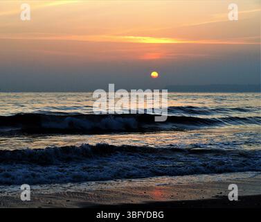 Sonnenaufgang über dem Meer von Tor Bay vom Paignton Beach, South Devon. Stockfoto