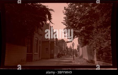 Dieses Foto aus dem Jahr 1913 zeigt Häuser mit Ziegeldach, die eine Straße in Zaandam, Niederlande, säumen. Die Arrases nahmen architektonische Merkmale niederländischer Häuser während ihrer Europafahrten auf. Stockfoto