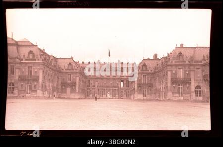 Ein Mann steht im Vorhof des Schlosses von Versailles, Frankreich. Die Familie Arras besuchte den Palast während ihrer Europatour 1913. Versailles ist berühmt für seine Größe, Pracht und seine historische Bedeutung als ehemalige königliche Residenz französischer Könige. Stockfoto