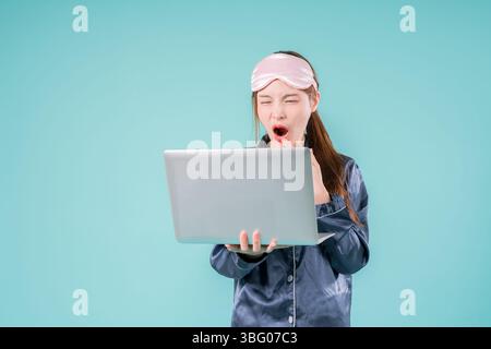 Asiatischer tragender Pyjama Unternehmer Notebook Social Lady, die online arbeitet, Eine junge Geschäftsfrau in Stockfoto