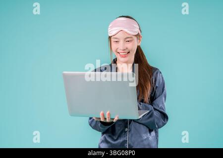 Asiatischer tragender Pyjama Unternehmer Notebook Social Lady, die online arbeitet, Eine junge Geschäftsfrau in Stockfoto