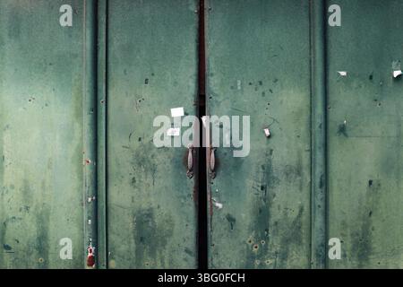 Geschlossener alter rostiger grüner Türhintergrund aus Metall Stockfoto