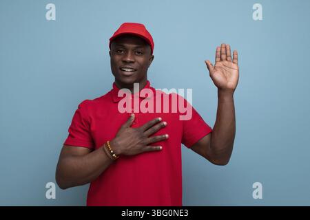 Farbe für Unternehmen. amerikanischer Mann mit rotem T-Shirt und Mütze auf dem Hintergrund mit Kopierraum Stockfoto