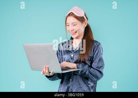 Asiatischer tragender Pyjama Unternehmer Notebook Social Lady, die online arbeitet, Eine junge Geschäftsfrau in Stockfoto