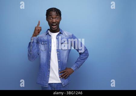 Ein eleganter, eleganter amerikanischer junger Mann mit Dreadlocks zeigt den Finger zur Seite Stockfoto