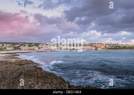 Abendlicher Blick auf Punta Prima Beach und Resort auf Menorca. Küstenstadt, Mittelmeer, Bewölkter Himmel, Touristenziel, Urlaubsort, Meereslandschaft Stockfoto