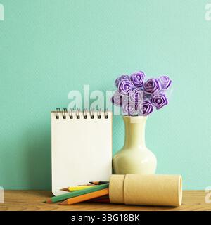 Leeres Notizbuch mit Blumen und Buntstiften auf Holztisch. Grüner Hintergrund Stockfoto