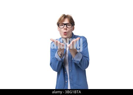 Junger, fröhlicher rothaariger Kerl in einem blauen Hemd über einem T-Shirt Stockfoto